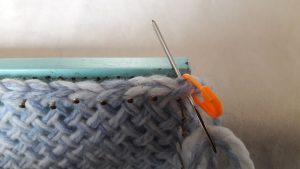 Put needle through 2 loops of the first stitch