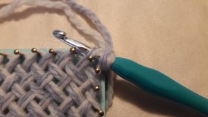 Crochet hook through the corner loop